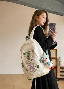 Vista detallada de la mochila de lona beige con estampado de galaxia y charm de peluche