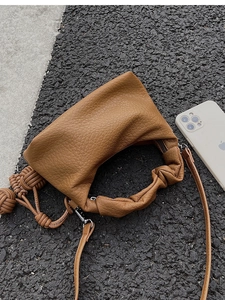 Détails de sac marron caramel avec texture litchi et poignée à plis élégante