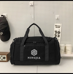 Detailed view of black nylon travel bag with multi-pocket design on pegboard display