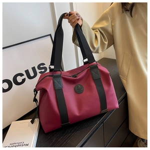Macro detail of wine red waterproof Oxford fabric travel bag with durable black handles
