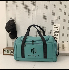 Large teal nylon travel bag with NINGJIA logo detail shown in lifestyle setting