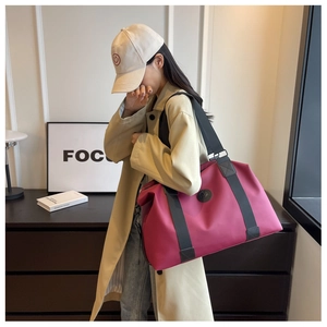 Detail of rose red waterproof oxford travel bag with reinforced black strap handles