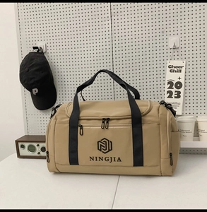 Detail of khaki large capacity nylon travel bag with black straps in lifestyle setting