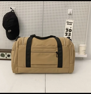 Detail of large nylon travel bag with heavy-duty handles and front zipper pocket
