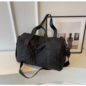 Detail der schwarzen Stepp-Reisetasche mit Nylon-Textur und MINGJIA-Markenlogo