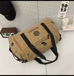 Macro view of khaki nylon travel bag showing durable fabric and zipper pocket detail