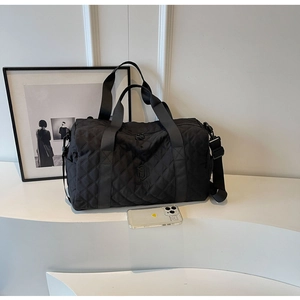 Details einer gesteppten schwarzen Reisetasche mit Größenvergleich zum Smartphone
