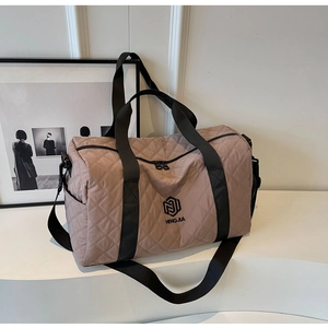 Detail einer großen gesteppten Reisetasche in Altrosa mit schwarzen Schultergurten