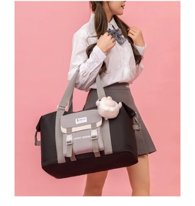Detail der Oxford-Reisetasche mit grauen Trägern und süßem Alpaka-Plüsch-Anhänger