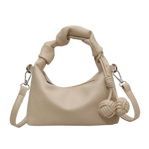 Sac à main plissé beige chic avec poignée nouée et boules tissées sur fond blanc neutre