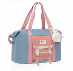 Detailansicht der blauen Oxford-Reisetasche mit rosa Riemen und Hasen-Anhänger