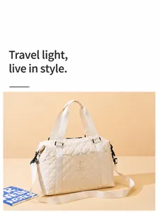 Detail of quilted beige travel tote bag with branded straps and large capacity