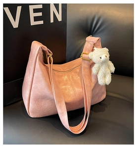 Detailed macro view of pink PU leather tote bag texture with cute plush bear charm