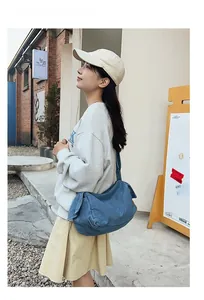 Outdoor shot of a blue denim shoulder bag showing natural washed texture and slouchy shape