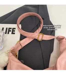 Detail of adjustable strap with gold buckle on pink lychee texture tote bag