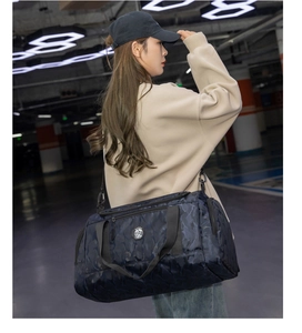 Dettaglio della borsa da viaggio camo blu con logo Sport in un ambiente urbano industriale