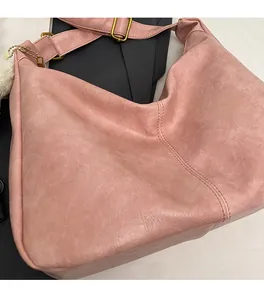Detail of pink retro textured PU leather tote bag with brass hardware and wide strap