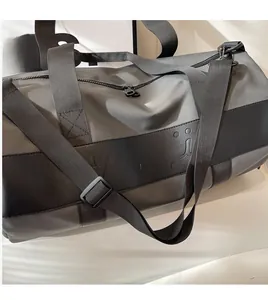 Detail of grey sports bag showing sturdy woven shoulder strap and metal hardware