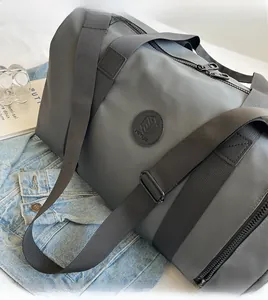 Detail of grey waterproof nylon travel bag with smooth zippers and adjustable shoulder strap