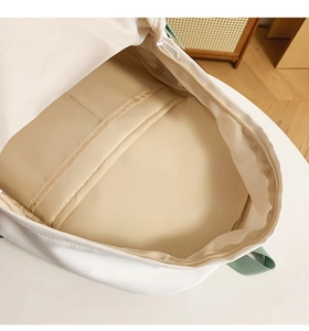 Vista macro del vano porta laptop e delle tasche interne dello zaino in tela beige