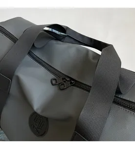 Detail of smooth double zippers and premium nylon texture on the gray travel bag