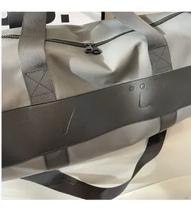 Close-up of gray nylon travel bag featuring embossed texture and durable black handles