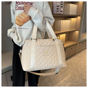 Detail of beige quilted oxford fabric travel bag with adjustable strap and NINGJIA logo