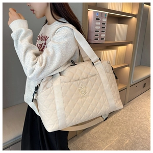 Detail of beige quilted travel bag with NINGJIA embroidery and crossbody strap