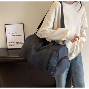 Detail of dark blue nylon travel bag with adjustable strap and side zipper pocket