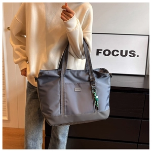Close-up of high-capacity grey nylon travel bag with double handles and logo detail
