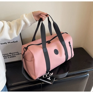 Detail showing pink nylon travel bag with black handles and side zipper pocket
