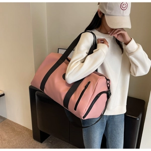 Detail of pink large travel bag showing matte waterproof fabric and side zipper pocket