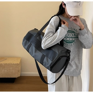 Detail of waterproof nylon travel bag with Minga logo and adjustable shoulder strap