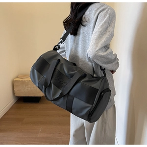 Detail of the durable nylon fabric texture and Uing logo on the grey sports bag