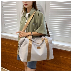 Gros plan d'un grand sac de voyage en tissu oxford gris porté par un mannequin
