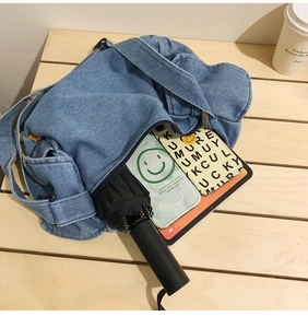 Close-up of spacious denim hobo bag interior showing organized daily essentials