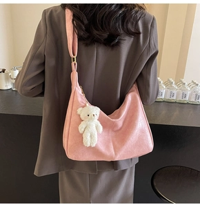 Pink matte leather underarm bag with cute white plush bear pendant on a shoulder strap