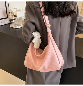 Detailed view of pink hobo bag with pebble leather texture and cute bear charm