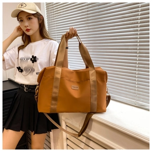 Détail du sac de voyage en tissu Oxford gingembre avec logo en cuir et larges bandoulières