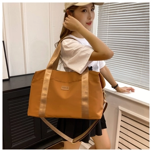 Sac de voyage en nylon caramel porté par un mannequin montrant sa grande capacité