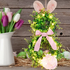 Illuminated Easter bunny wreath with green leaves, pink ears and warm LED lights