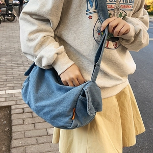 Large denim dumpling bag in blue, casual crossbody style with wide shoulder strap