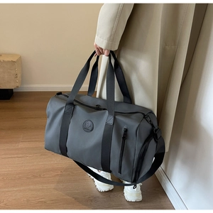 Close-up of a large dark grey nylon travel bag with durable straps and side pockets