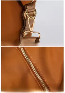 Détail du crochet en métal doré et fermeture éclair sur sac de voyage marron