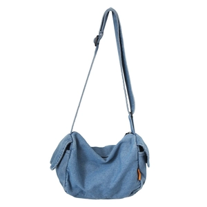 Blue denim half-moon sling bag with side pockets and adjustable shoulder strap