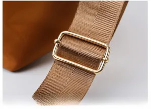 Détail de la bandoulière en nylon marron avec boucle réglable rectangulaire dorée