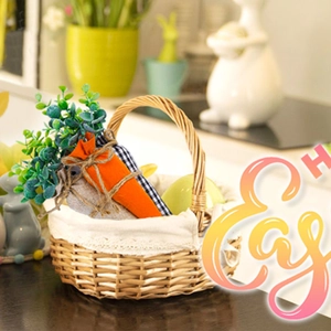 Easter basket featuring fabric carrots and green foliage in a woven willow basket