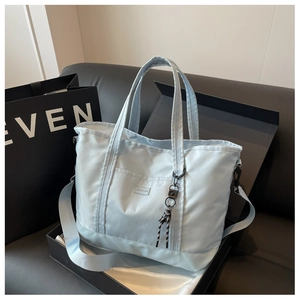 Detail of light blue large capacity tote bag with woven pendant in high-end gift box
