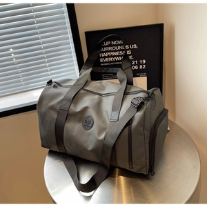 Close-up of modern grey nylon travel bag showing durable handles and adjustable shoulder strap