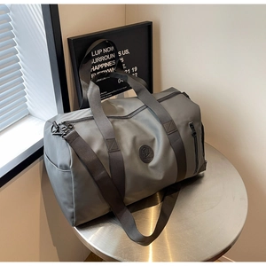 Detail of grey nylon travel bag with reinforced handles and adjustable shoulder strap